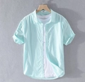 Detail view of mint green cotton linen short sleeve shirt on hanger with white t-shirt - Grass Green