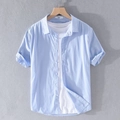 Men's light blue short sleeve linen shirt styled over a white t-shirt on a grey wall - Sky Blue