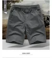 Detailed close-up of gray cargo shorts showing elastic waist with button and belt loops - M / Bottoms / Gray