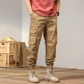 Close-up of khaki cargo pants featuring large side flap pockets and elastic cuffs - EU 29 / Khaki