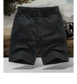 Detailed close-up of men's black cargo shorts featuring elastic waist and cotton fabric - M / Bottoms / Black