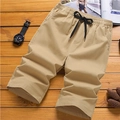 Khaki Herren Cargo-Shorts mit elastischem Bund und Kordelzug auf Holzhintergrund - M / Khaki