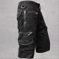 Detail of tactical cargo shorts featuring multiple zipper pockets and a metal D-ring attachment - Black