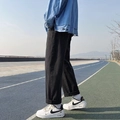 Schwarze lockere Herren-Jeans im Straight-Leg-Stil mit weißen Sneakern auf blauem Grund - S / Schwarz
