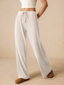 Dettaglio dei pantaloni larghi in maglia a costine bianche con coulisse in vita elastica - S / Bianco