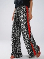 Dettaglio dei pantaloni larghi leopardati con vita elastica e strisce rosse laterali - S / Nero