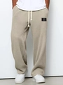 Detail of men's waffle knit joggers with elastic drawstring waist and woven label - S / Khaki