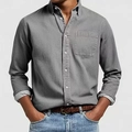 Dettaglio ravvicinato della camicia casual da uomo grigio scuro con bottoni bianchi e tasca sul petto - S / Grigio