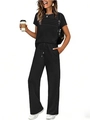 Detail of black two-piece set featuring pleated short sleeve top and wide-leg trousers - Black
