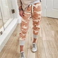 Detail view of camouflage joggers featuring a white drawstring waist and grey ribbed cuffs - S / Bottoms / Orange