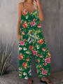 Deep green floral wide-leg jumpsuit with v-neck straps and side pockets on a model - S / Green