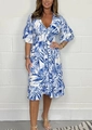 Close-up of tropical palm leaf print and smocked high waist detail on summer dress - Blue