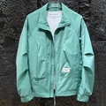 Detail of mint green lightweight jacket showing logo label and fabric texture - M / Green