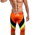 Detail der knielangen Herren-Badehose in Orange mit neongrünem V-förmigem Kontrast-Design - M / Orange