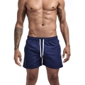 Detail view of navy blue quick-dry swim trunks with elastic waistband and white drawstrings - Dark Blue