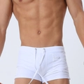 Detail view of men's white swim trunks showing the drawstring waist and side zipper pocket - White