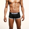 Vue de face d'un boxer en coton noir avec passepoil blanc et ceinture élastique griffée - S / Noir