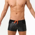 Detail der dunkelgrauen Badehose mit Palmenprint und leuchtend orangem Kordelzug - M / Hibiskus Schwarz