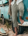 Detail of sage green linen texture shorts with drawstring waist on beach background - Light Green