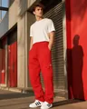 Detail of red cargo joggers showing elastic waistband and side pocket with small woven label - S / Bottoms / Red