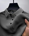 Gros plan d'un polo pour hommes avec tissu en maille texturée 3D et détails du col - S / Gris clair