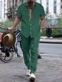 Detail shot of dark green textured short-sleeve shirt and matching trousers set for men - Green