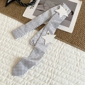 Close-up of a trendy white silk polka dot belt decorated with leather star patches and studs - Polka Dot Style / White Base Black Polka Dot
