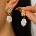 Primo piano di orecchini a fiore dorato con eleganti perle bianche barocche irregolari - Orecchini a Bottone (A-649) / Oro