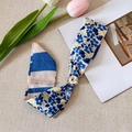 Dettaglio di una collana foulard di seta vintage con un elegante ciondolo di perla - Stile Rotondo Perla / Stampa Floreale Blu e Gialla