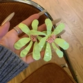 Detailed macro view of large lime green floral drop earrings with pink center detail - Green