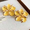 Close-up detail of yellow drip oil flower earrings with gold metallic accents. - Stud Earrings / Yellow