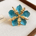Primer plano detallado de un anillo de flor de esmalte azul con acentos metálicos dorados - Anillo / Cian