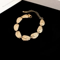 Close-up of a vintage gold hammered oval link bracelet on an elegant black background. - Bracelet / Gold