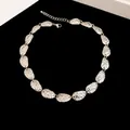 Vintage silver necklace with hammered textured leaf-shaped plates on black background - Short Necklace / Silver