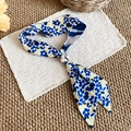 Close-up of French summer silk scarf necklace with blue tulip pattern and pearl bead. - Blue/Yellow