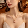 Detalle de un elegante collar dorado con colgante de concha rosa y estrella en una modelo - Estilo Estrella Concha Dorado (T057) / Dorado