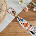 Close-up detail of colorful abstract print silk scarf necklace with pearl slider - Coffee Print