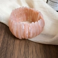 Close-up of pink marbled acrylic elastic bracelet with semi-circular geometric design. - Pink