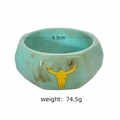 Gros plan sur un large bracelet y2k en résine marbrée sarcelle avec un charm tête de taureau jaune - Décoration tête de taureau / Émeraude