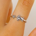 Dettaglio macro di un anello aperto in argento con tartaruga e stella marina al dito - Stile Tartaruga e Stella Marina (0041)