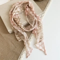 Close-up of a French vintage floral silk scarf with pink abstract print patterns on an old book. - Pink And Green Style