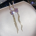 Close-up of elegant purple rose earrings with sparkling crystals and long gold tassels - Hook Style / Gold-Purple