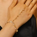 Close-up of golden finger bracelet featuring sparkling zircons and delicate metal sequins - 亮片仿钻连指手链(7016) / Gold