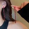 Primo piano di eleganti orecchini pendenti lunghi con scintillanti cristalli rossi. - Stile nappine marquise rosso (7#) / Canna di fucile
