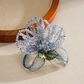 Detailed macro view showing the intricate glass beads and metallic wire embroidery of the brooch - Blue