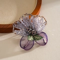 Close-up detail of a vintage lavender glass beaded flower brooch with embroidery. - Purple
