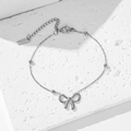 Elegante pulsera de cuentas de acero inoxidable plateado con un detalle de lazo sencillo - Estilo Lazo (E2042) / Color acero