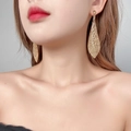 Orecchini pendenti dorati di lusso con strass AB scintillanti indossati da una modella - Stile Rombo Strass Oro (KE004LT)