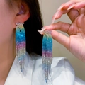 Orecchini pendenti di lusso con strass sfumati indossati da una modella elegante - Sfumato Oro Blu Viola Chiaro (KE001RB)