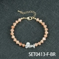 Handgemaakte kralenarmband met perzikkleurige kralen en een kristallen accent - Witte Kristal En Zonnesteen Armband